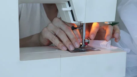 Process of inserting thread into needle of industrial white sewing machine. Stock Footage 180385709