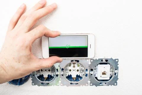The process of installation electrical sockets level with a smartphone Stock-Fotos