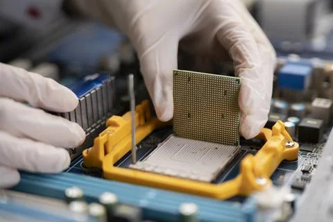 The process of Installation of processor in CPU socket, hands in gloves holding Foto stock