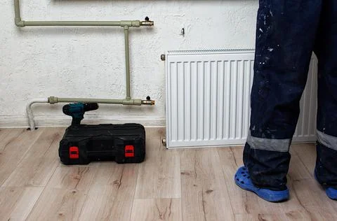 The process of installing a battery to water pipes. Heating system. Nearby st Stock Photos