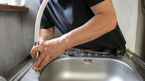 The process of installing a flexible faucet on a kitchen sink Stock Photos