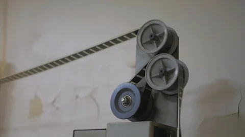 The process of installing old film into the reel to watch a movie at the cinema Stock Footage 93713151
