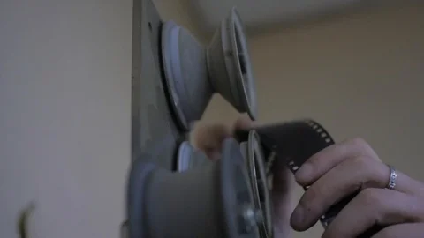 The process of installing old film into the reel to watch a movie at the cinema Stock Footage 93713271