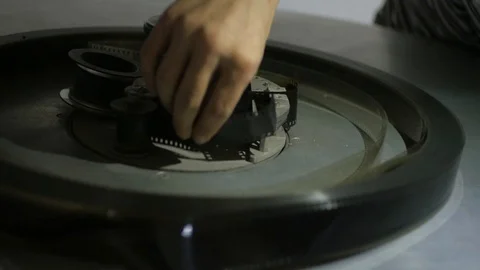 The process of installing old film into the reel to watch a movie at the cinema Stock Footage 93713380