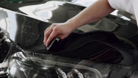 Process of installing of Paint Protection Film on new black car in professional Video stock 150918014