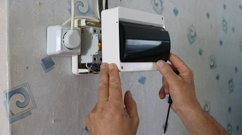 The process of installing a plastic electrical panel on a wall Stock Photos