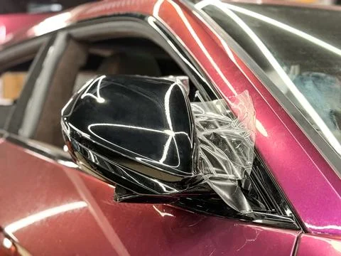The process of installing PPF film on the side mirror. Stock Photos