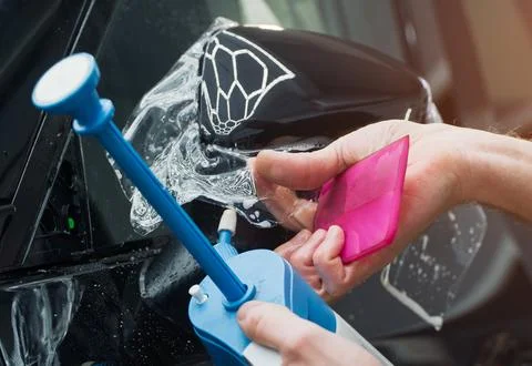 The process of installing PPF on the side of the car. Stock Photos