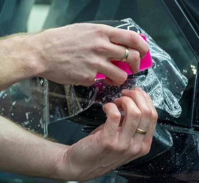 The process of installing PPF on the side of the car. Stock Photos