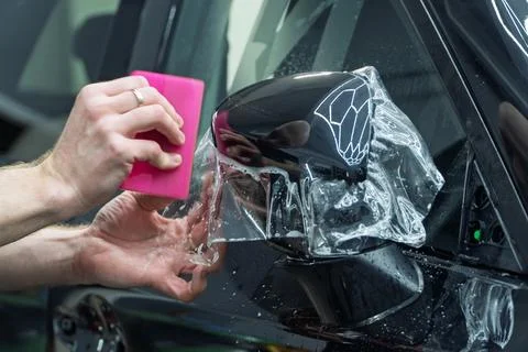The process of installing PPF on the side of the car. Stock Photos