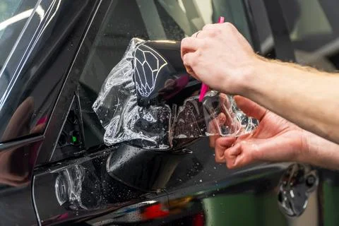 The process of installing PPF on the side of the car. Stock Photos