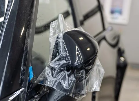 The process of installing PPF on the side of the car. Stock Photos