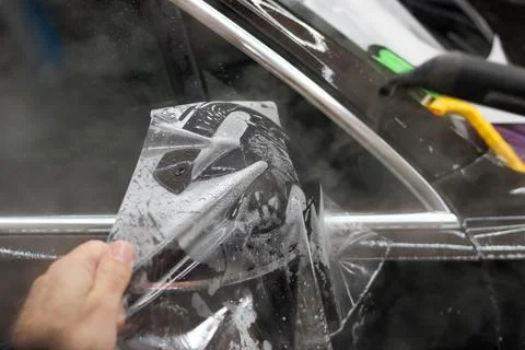 The process of installing PPF on the side mirror. Stock Photos