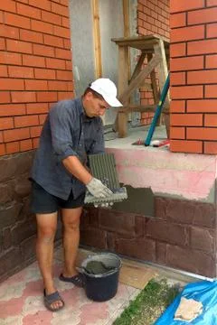 The process of installing sandstone decorative tiles on the foundation of the 스톡 사진
