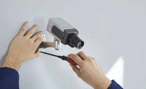 Process of installing surveillance camera on wall for security inside new home Stock Photos