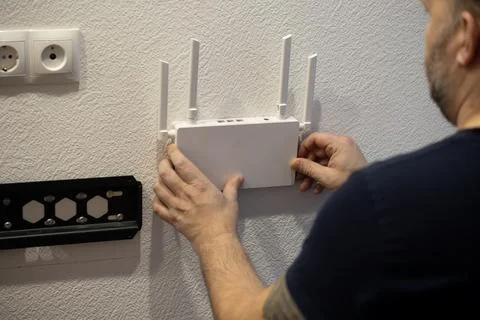 The process of installing a wireless router on a wall to improve internet Stock Photos