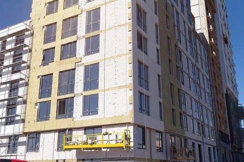 The process of insulating external walls in a multi-storey building under con Stock Photos