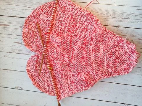 The process of knitting and crocheting pillows in the shape of a pink heart Stock Photos