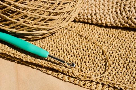 The process of knitting a raffia bag, a skein of yarn, a crochet hook Stock Photos