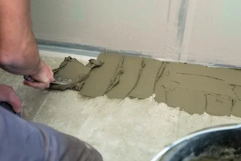 The process of laying ceramic floor tiles with a herringbone pattern. Foto stock