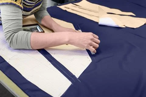 The process of laying out the details of the pattern on the fabric. Stock Photos