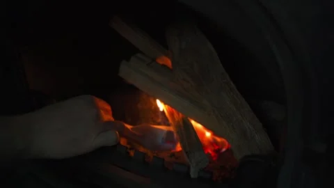 The process of lighting a fire in a fireplace, close-up. A piece of paper is Stock Footage 323054898