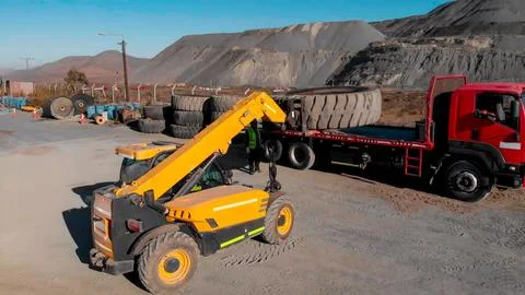 Process of loading and transporting giant tires with heavy machinery for re.. Stock Photos