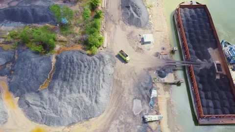 The process of loading coal onto barges using heavy transport cars Stock Footage 263611884
