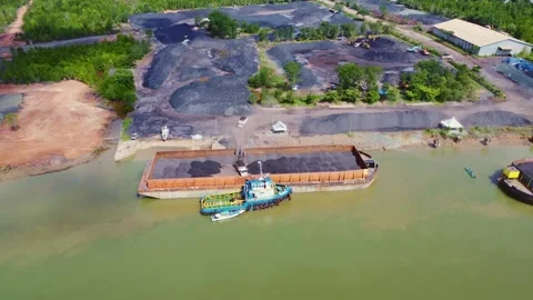 The process of loading coal onto barges using heavy transport cars Stock Footage 263611944