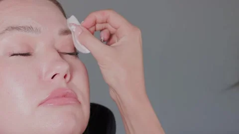 The process of makeup removal using a cotton pad during a beauty treatment is Stock Footage 317371889