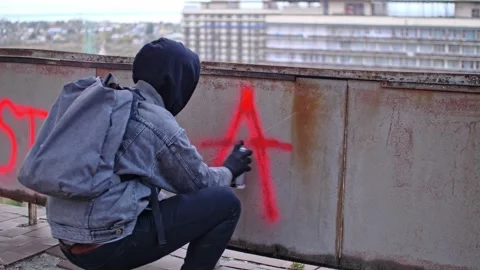 Process of making anarchy graffiti by young protester in a hood Stock Footage 143349876
