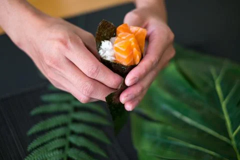 The process of making and decorating salmon Temaki Hand Roll. Stock Photos