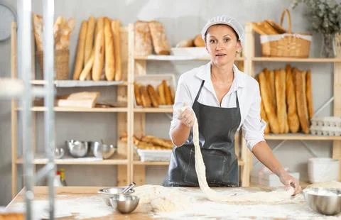 Process of making baguette, loaf or bread in bakery - femsle baker kneads and 写真素材