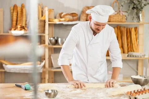 Process of making baguette, loaf or bread in bakery - baker kneads and rolls the Stock Photos