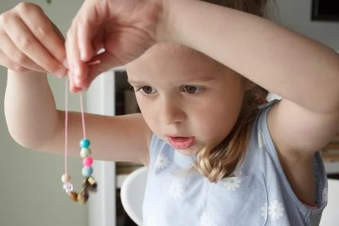 Process of making a bracelet from a thread and colored beads, concept of hobb Stock Photos