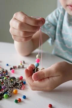 Process of making a bracelet from a thread and colored beads, concept of hobb Stock-Fotos