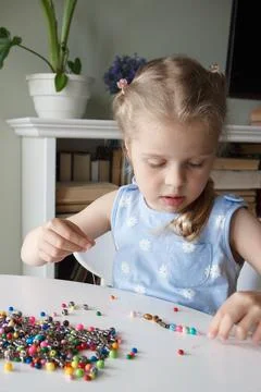 Process of making a bracelet from a thread and colored beads, concept of hobb Foto stock