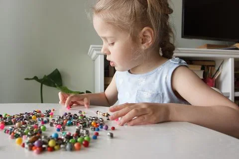 Process of making a bracelet from a thread and colored beads, concept of hobb Stock Photos