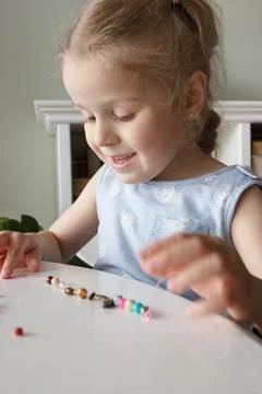 Process of making a bracelet from a thread and colored beads, concept of hobb Stock-Fotos