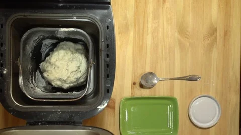 The process of making bread in an electric home bakery on a wooden kitchen table Stock Footage 75677188