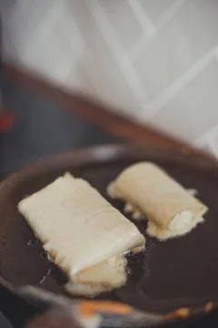 The process of making breakfast: a tortilla with cheese is fried in a pan. Stock Photos