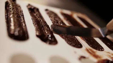 The process of making Brownie dessert.Chocolate brownie cake is put into a mold Stock Footage 208945090