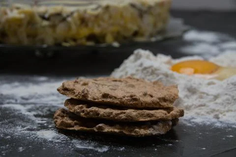 The process of making a cake. Cake cakes, flour and raw egg on a dark backgro Foto stock