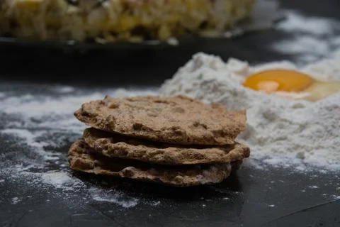 The process of making a cake. Cake cakes, flour and raw egg on a dark backgro 스톡 사진