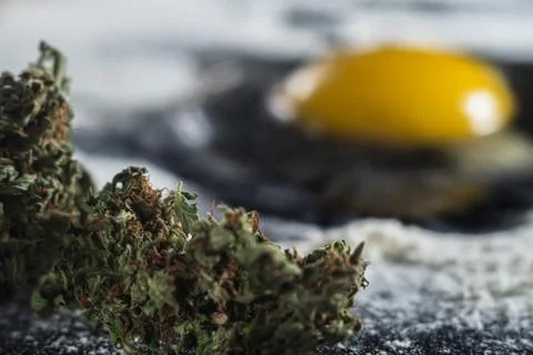 The process of making cannabis pastries. raw broken egg, a rolling pin, flour Foto stock