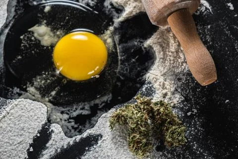 The process of making cannabis pastries. raw broken egg, a rolling pin, flour 스톡 사진