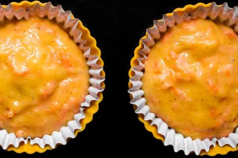 The process of making carrot muffins. Dough for cakes in paper molds on a bla Foto stock