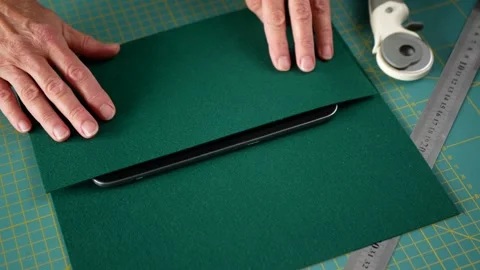 Process of making a case for a tablet from green felt 動画素材 277969712