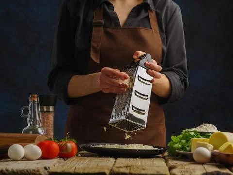 The process of making cheese. Professional chef grates cheese on a wooden tab Stock Photos