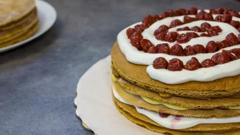 The process of making a cherry pie with cream, side view Stock Photos